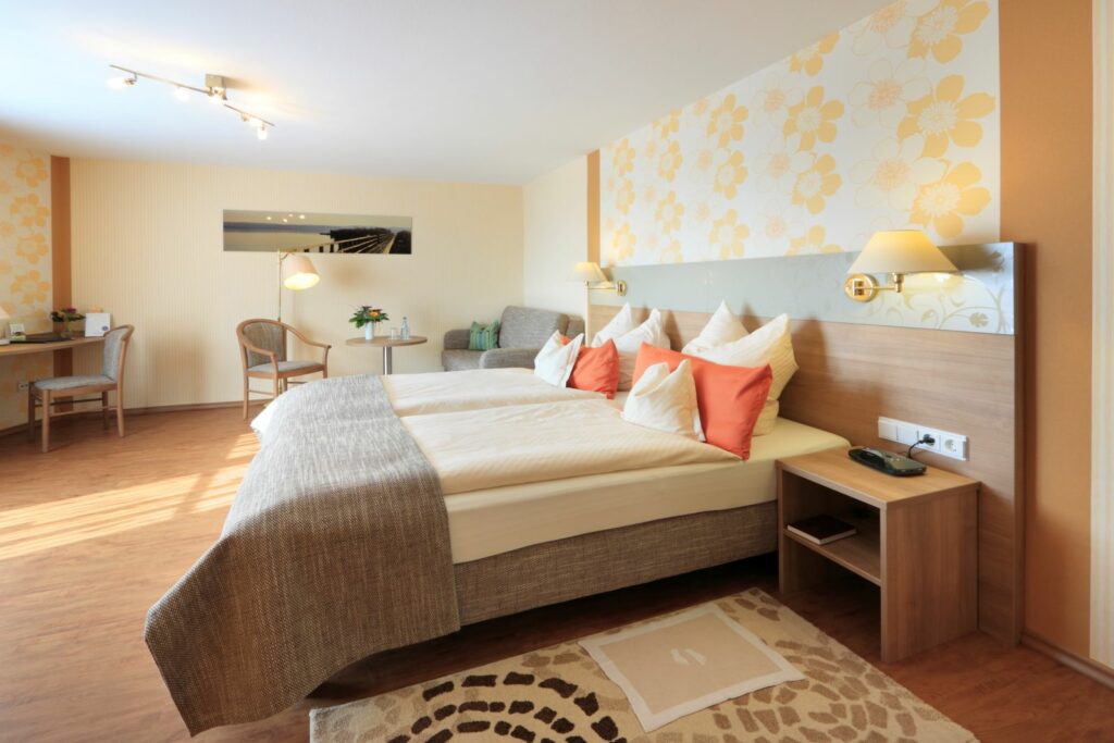 Geräumiges Premium-Doppelzimmer mit großem Bett, Sitzecke, Schreibtisch und warmen Farbakzenten