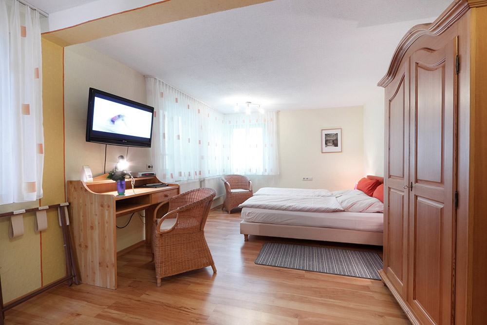 Premium Appartement im Gästehaus Edith mit Bett, Schreibtisch, Flachbild-TV und großem Holzschrank